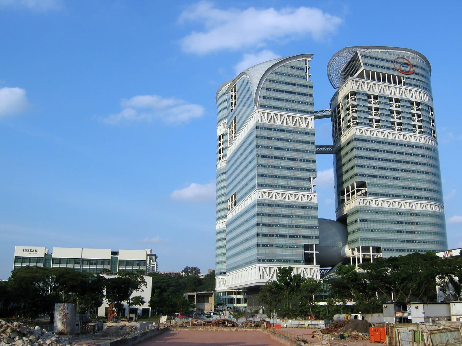 The twin curved glass towers of Fusionopolis at one-north, Buona Vista — the R&D and tech precinct near Bloomsbury Residences, with the INSEAD campus visible at left.