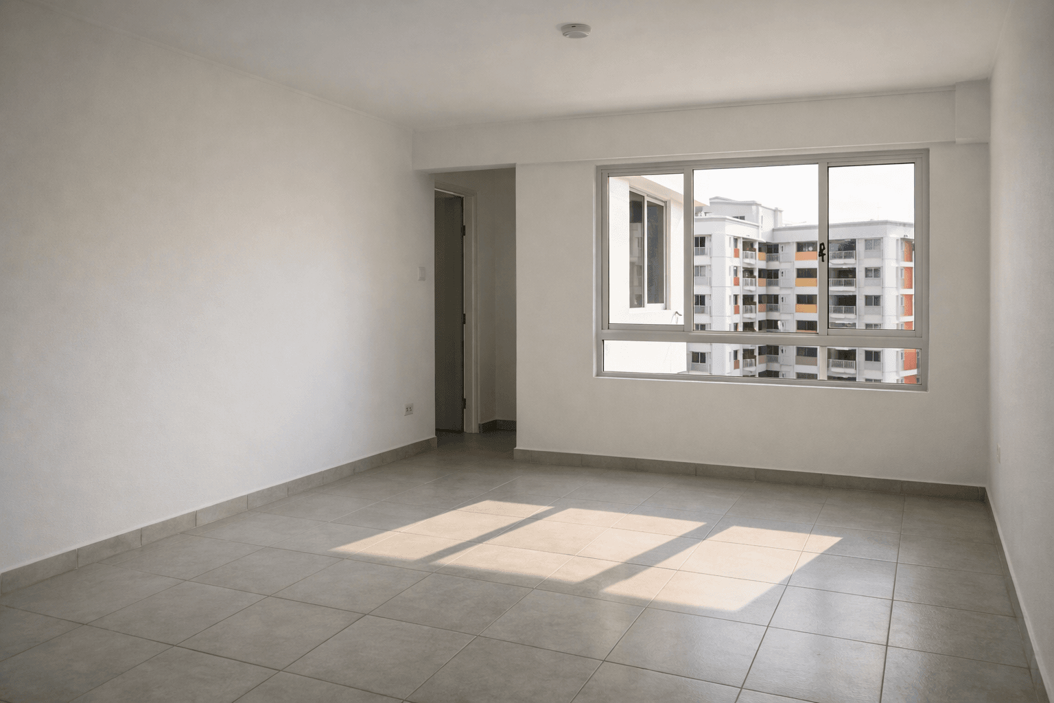 An empty, newly completed HDB flat with bare walls and afternoon light.